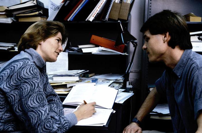 80年代，塔利亚在她的办公室里给一个学生提供咨询.